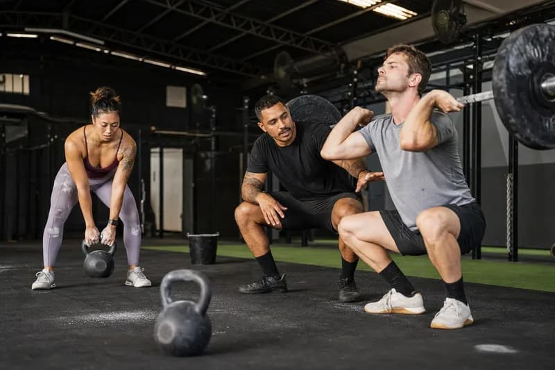 Treino de CrossFit com barra e kettlebell em box